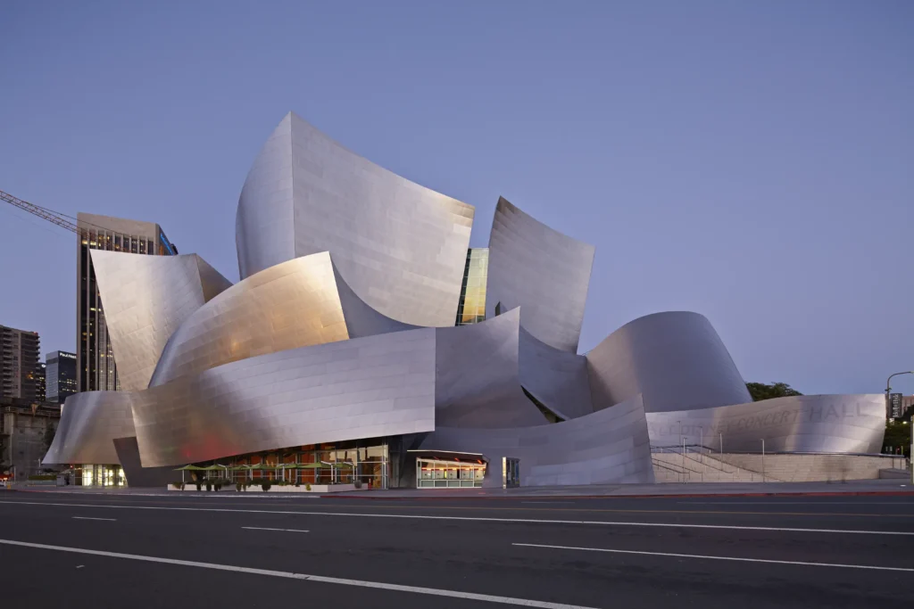 Warm late evening light glowing at the glass base of Walt Disney Concert Hall at night