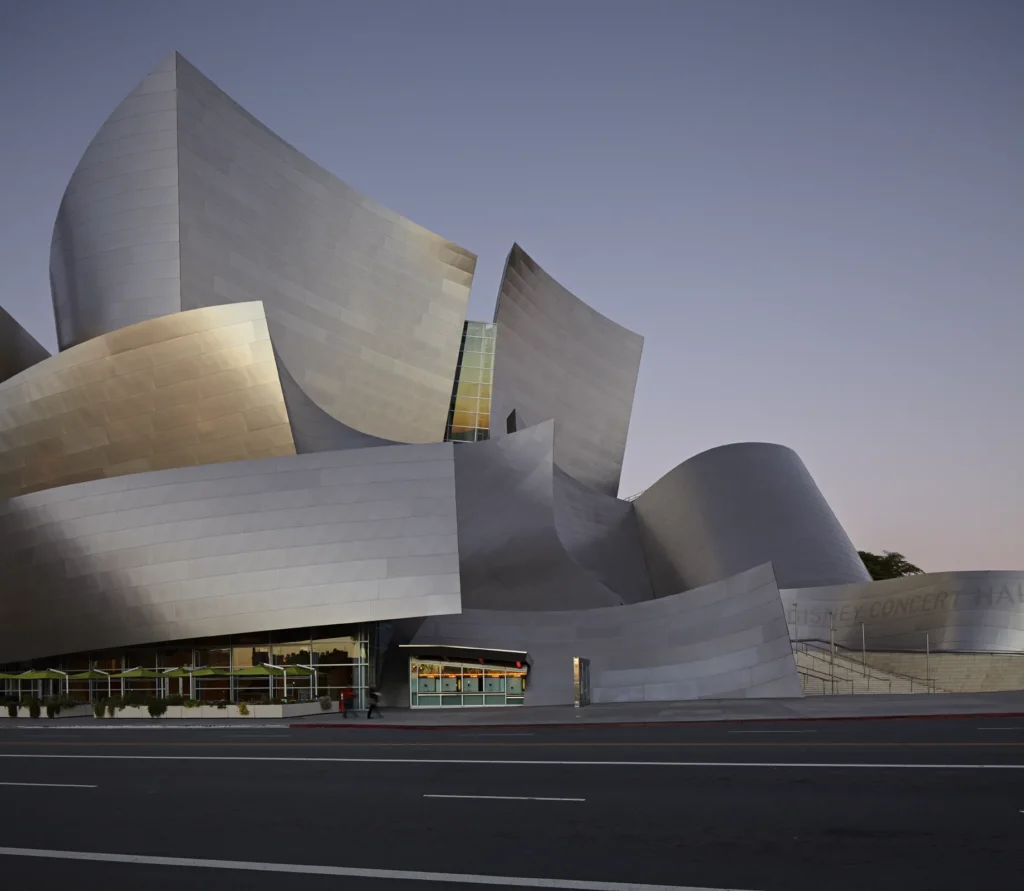 Stainless steel forms of Walt Disney Concert Hall with illuminated lobby below