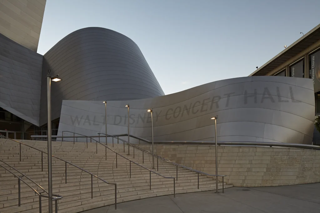 Walt Disney Concert Hall entrance signage on the curved stone wall in Los Angeles