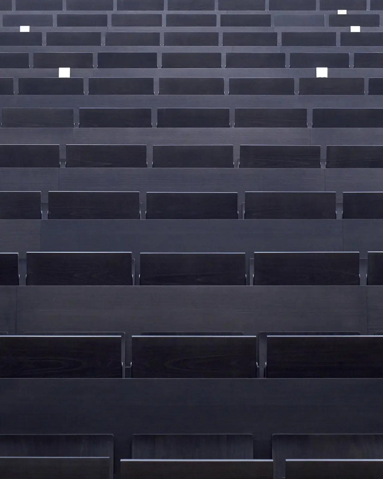 Black wooden rows of seats in the new auditorium of Hochschule Bochum by Nils Koenning