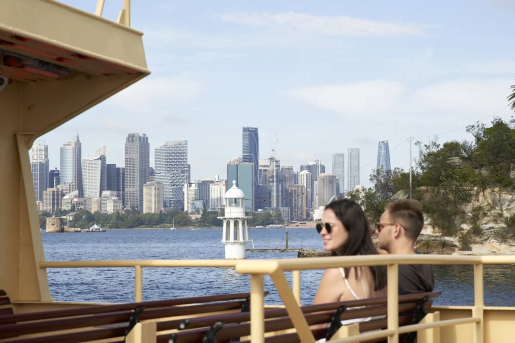 Visitors looking across Sydney Harbour and CBD skyline with Quay Quarter Tower from ferry