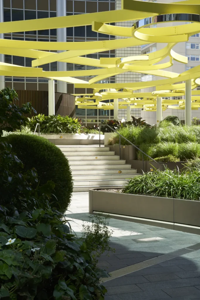 Yellow sculptural canopy above planted terraces at Quay Quarter Tower