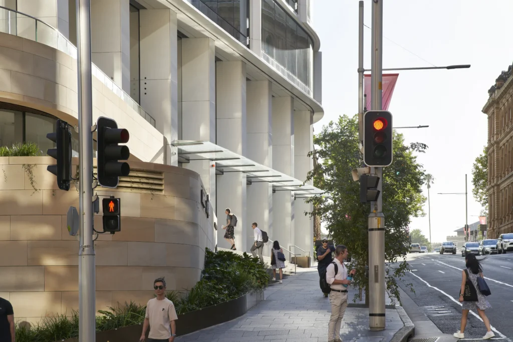 Street-level entrance of Quay Quarter Tower with pedestrians on stairs entering