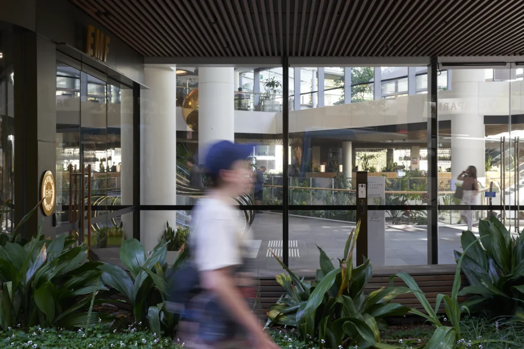 Pedestrian walking past the glazed ground floor of Quay Quarter Tower in Sydney