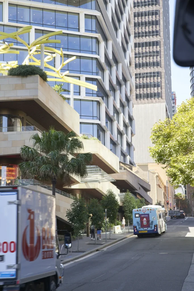 Street scene near Quay Quarter Tower with bus and pedestrians in Sydney CBD